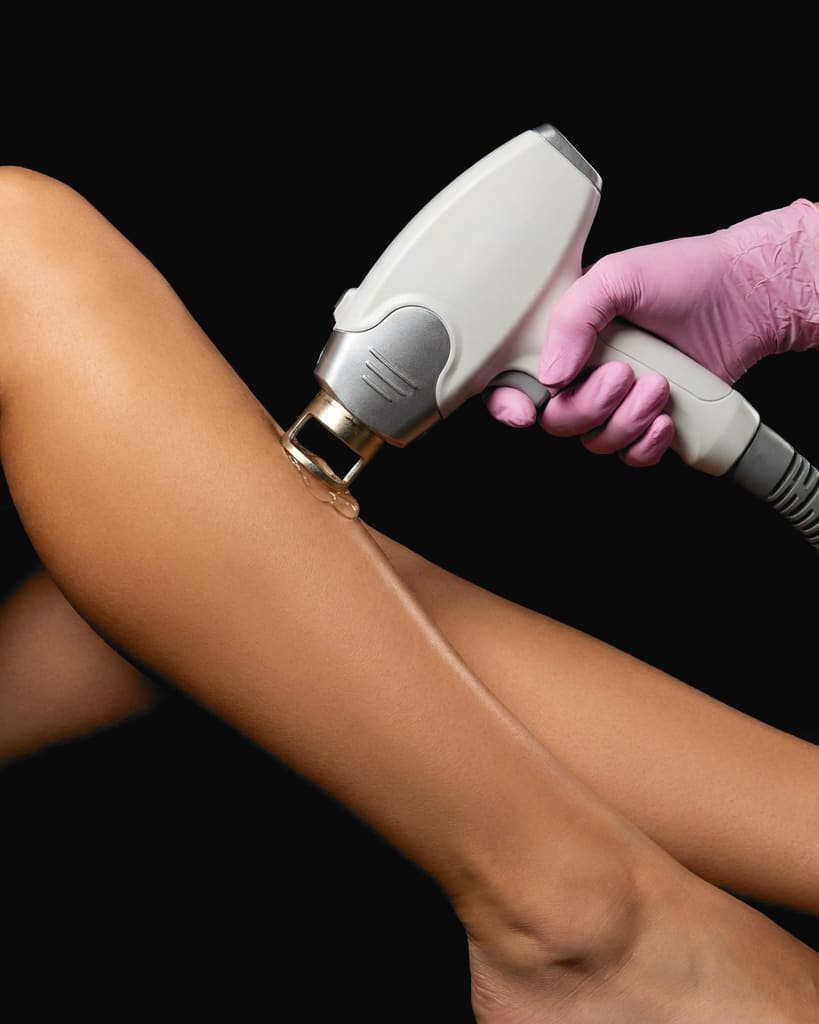 A laser handpiece on a calf, held in a pink gloved hand