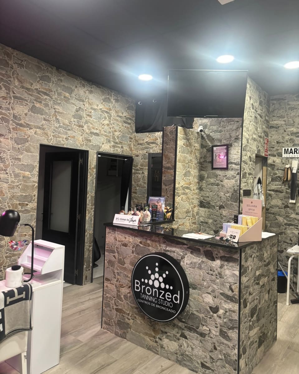 Reception as you walk in: stone walls, the Bronzed desk with its round lightbox, and the doors through to the rooms