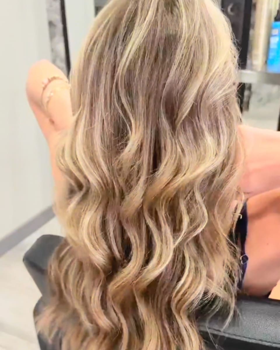 Sunkissed balayage in loose waves, from behind, in the styling chair