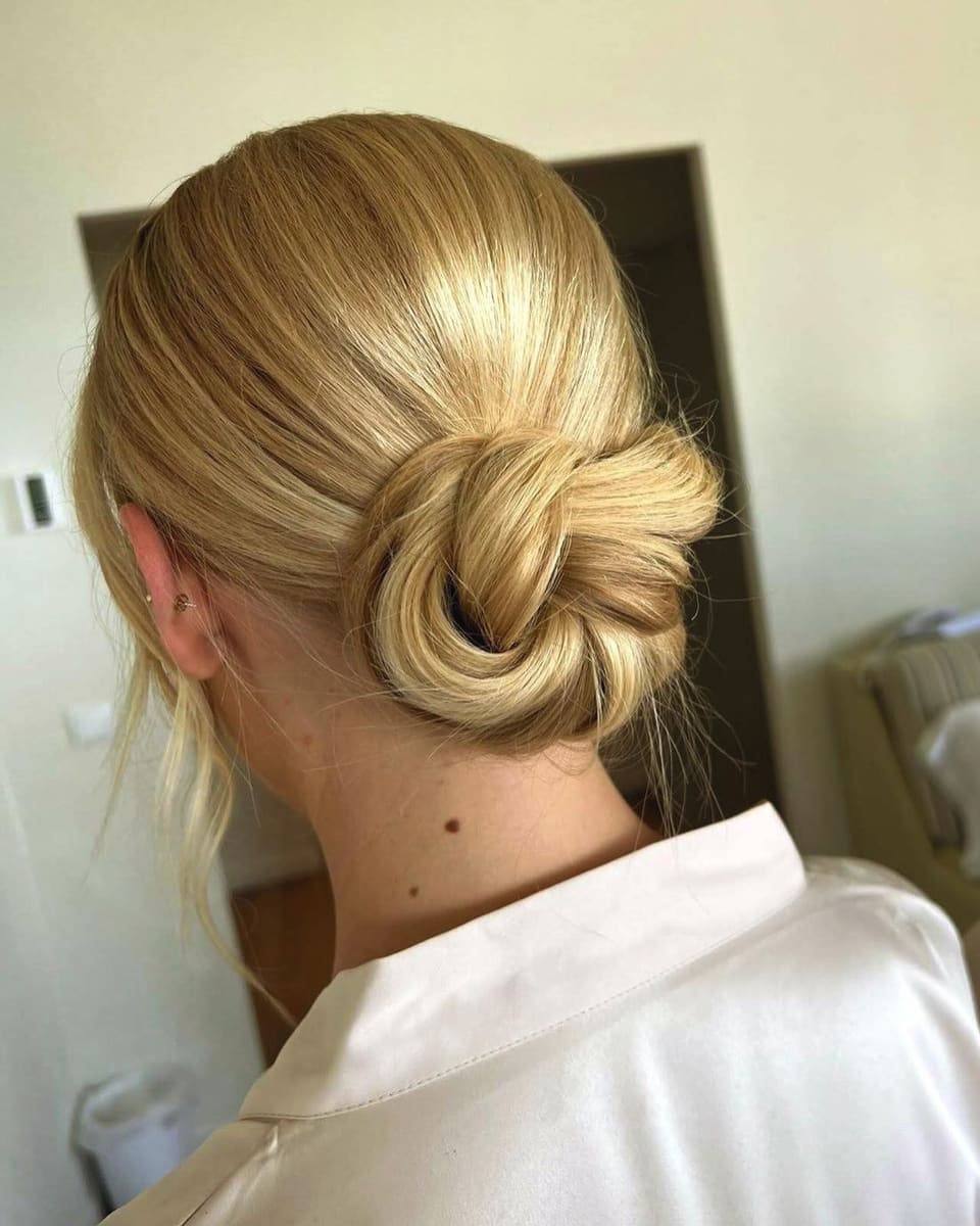 A sleek blonde low knot, from behind