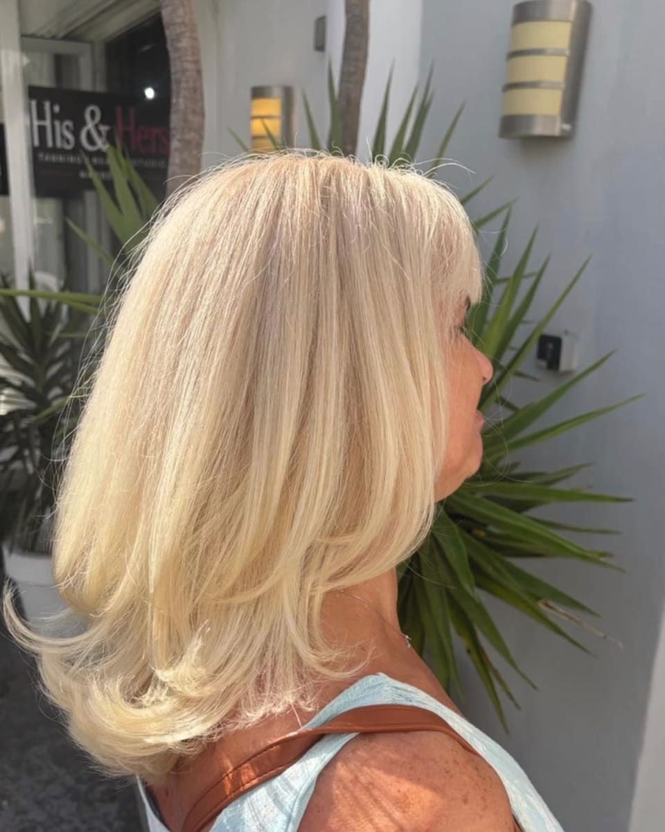 A bouncy silver blonde blow dry, in profile, outside the His & Hers shopfront