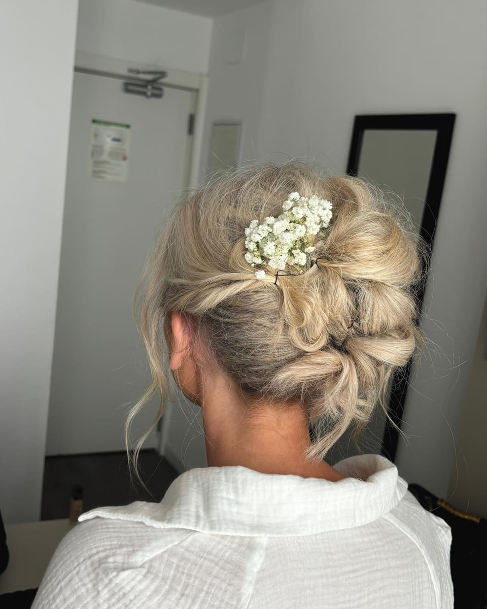A blonde bridal updo with gypsophila, from behind