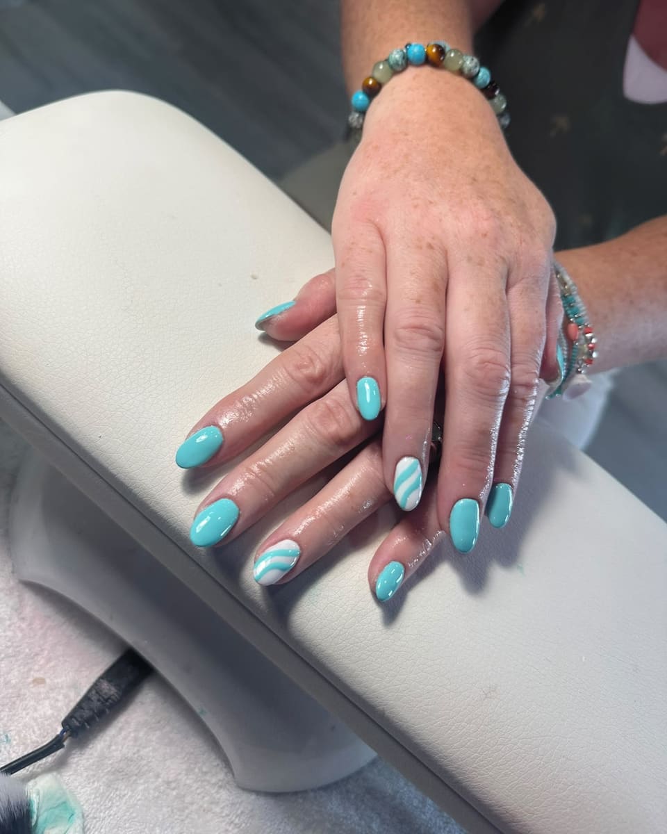 Turquoise almond gel nails on the nail desk cushion