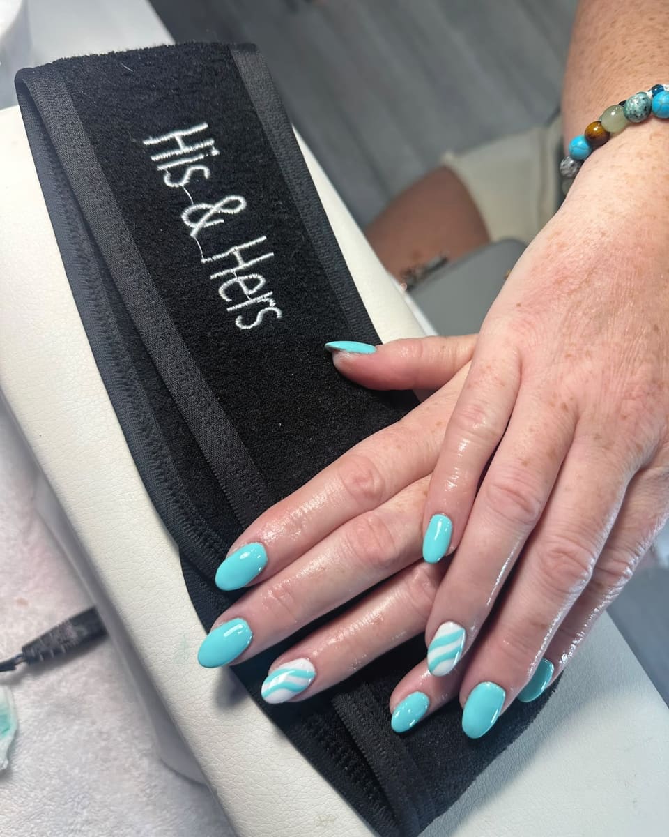 Turquoise gel nails with a swirl design, resting on a His & Hers headband