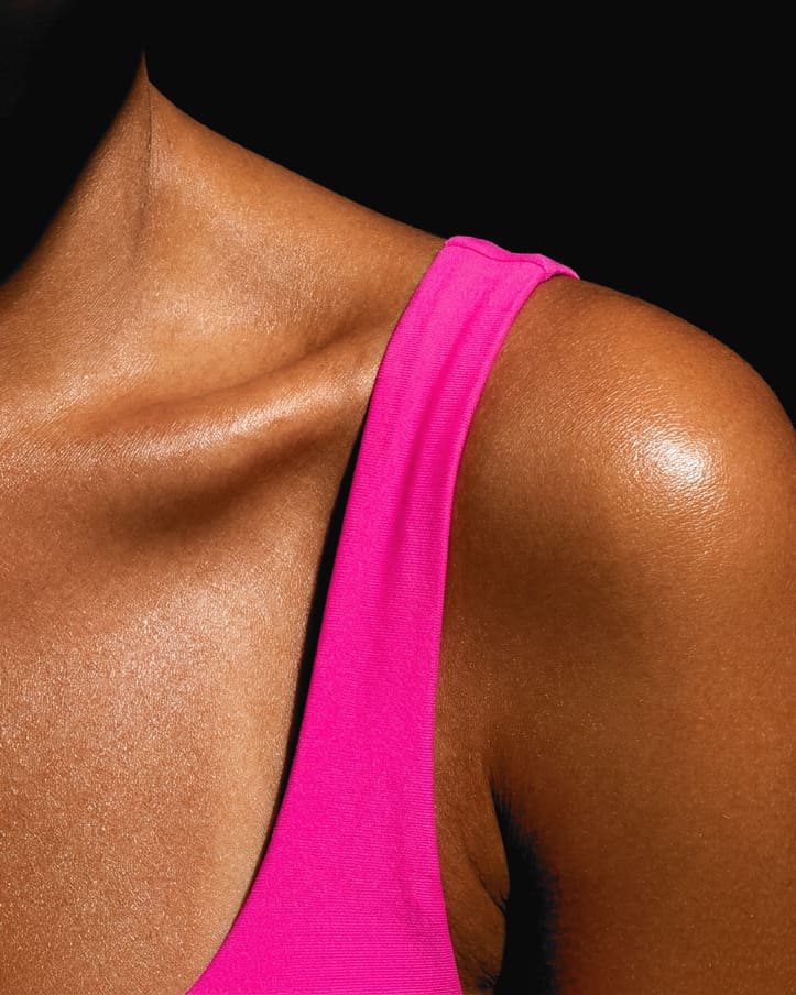 A tanned shoulder and collarbone with a hot pink strap