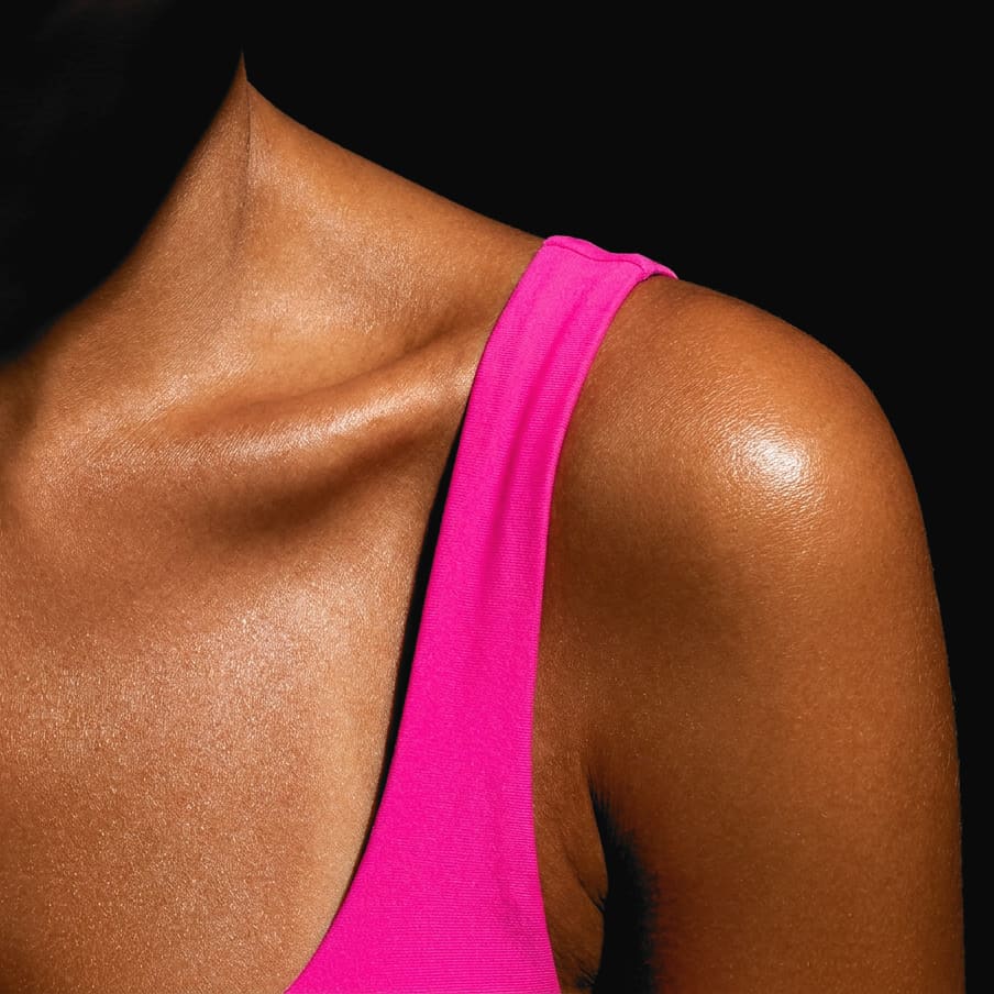 A tanned shoulder and collarbone with a hot pink strap